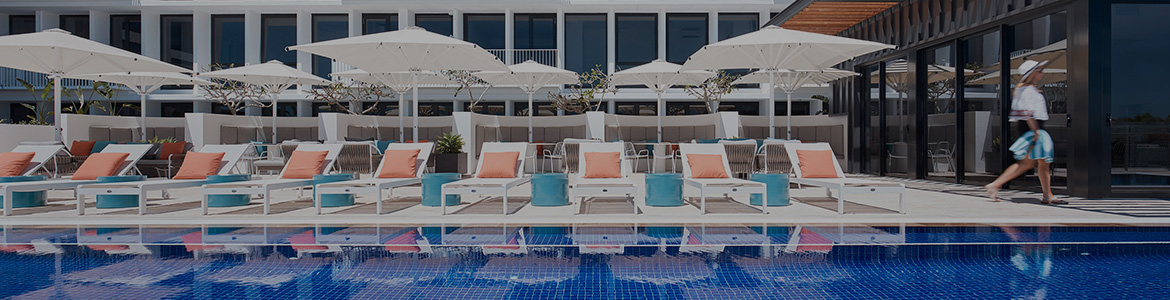 Pool in front of a large white hotel